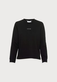 Musta collegepaita, valmistettu puuvillasekoitteesta, jossa pitkät hihat, pyöreä pääntie ja pieni valkoinen logo rinnassa. Resorit hihansuissa ja helmassa.