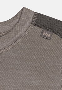 Grijs gebreid stof met een textuurpatroon; heeft een ronde hals, contrasterende schouderpaneel en een klein logo label.