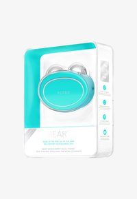 Appareil Foreo BEAR en turquoise et argent. Forme arrondie et ergonomique, présenté dans un emballage transparent sur fond blanc avec les caractéristiques du produit énumérées.