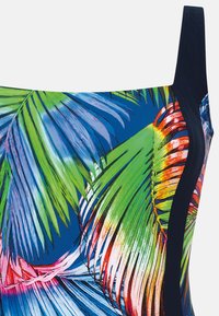 Badedragt i flere farver med et tropisk palmebladsprint på en blå baggrund, med sorte sidepaneler og et tekstureret design.