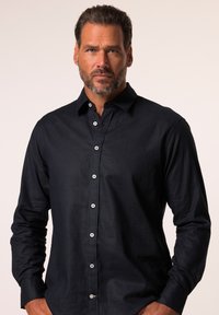 Camicia button-up blu scuro con maniche lunghe, bottoni bianchi e una superficie liscia. Presenta un colletto classico e un design aderente.