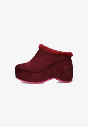 Zoccolo in suede bordeaux con colletto rosso peloso, suola a piattaforma elevata con base in gomma rosa, caratterizzato da una superficie liscia e forma arrotondata.
