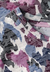 Katoenen T-shirt met een meerkleurig abstract patroon in tinten paars, blauw en grijs, met een ronde halslijn en gestikte randen.