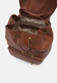 Sac seau en cuir marron avec quincaillerie dorée, fermeture à cordon et poche zippée à l'avant. L'intérieur dispose d'une doublure à motifs.