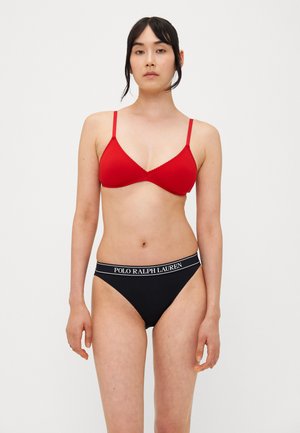 Rode driehoek beha met dunne bandjes en gegolfde randen, gecombineerd met zwarte hoog-waisted bikini onderbroek met een witte logo tailleband.