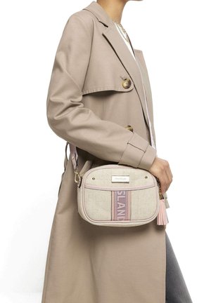 Borsa a tracolla in tessuto beige con accenti rosa, forma arrotondata, dettagli in oro e nappina. Presenta la scritta del marchio in evidenza sul davanti.