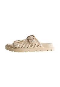 Sandalia deslizante beige tejida con dos hebillas ajustables, suela de goma y parte superior texturizada. Diseño plano con puntera y talón abiertos.