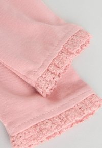 Rosa Baumwollhosen mit weich strukturiertem Volant am Saum, ausgeführt mit einer glatten Oberfläche und einem leicht gebrushten Innenfutter für maximalen Komfort.