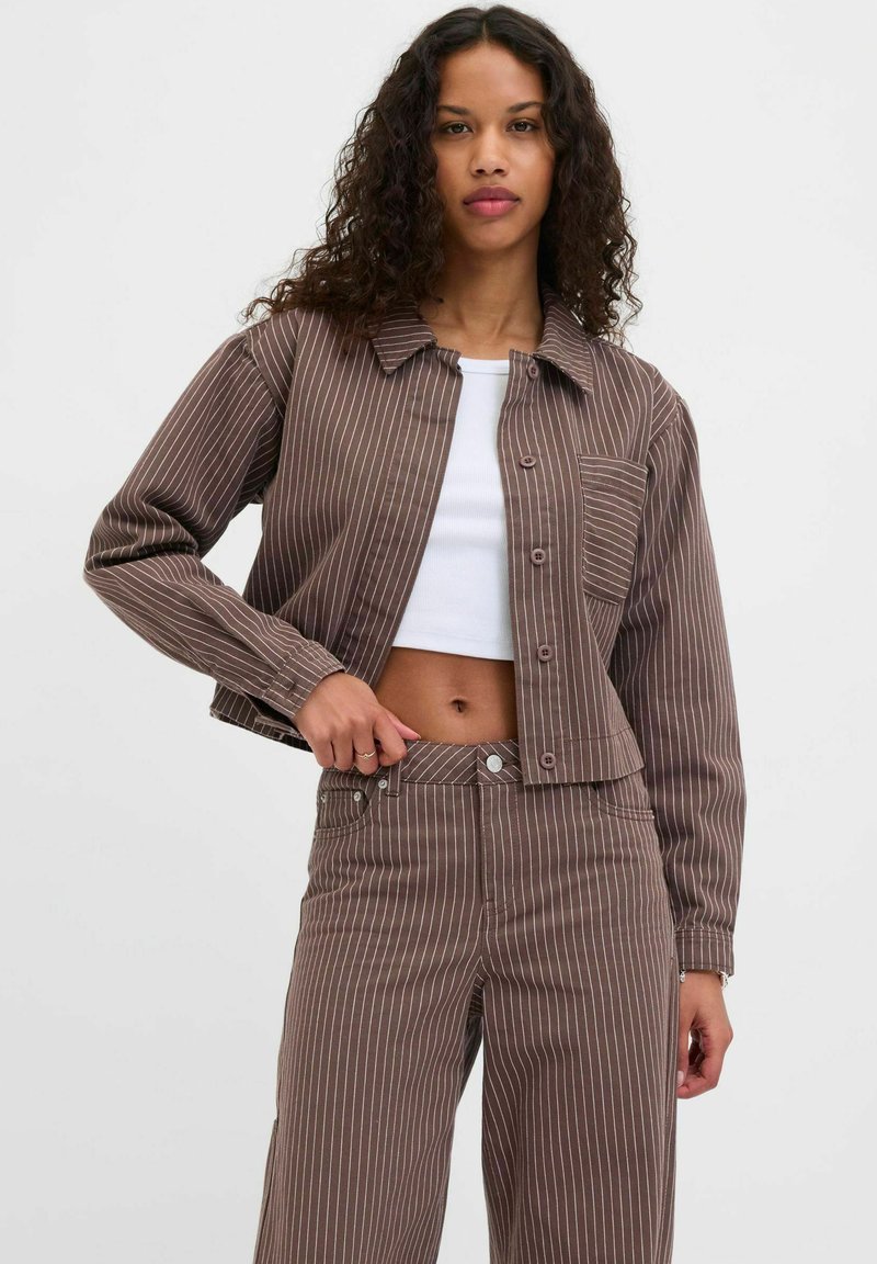 Brown striped denim jacket with a classic collar, front buttons, chest pocket, and paired with matching high-waisted pants.