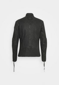 Czarna skórzana kurtka o gładkiej fakturze, z kołnierzem, detalami szwów i suwakami przy mankietach. Prostokątna naszywka na plecach.