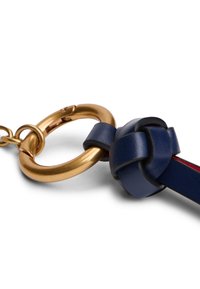 Porte-clés en cuir bleu marine avec un anneau circulaire doré, doté d'un détail en cuir noué et d'une doublure intérieure rouge. Texture lisse.