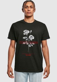 Černé bavlněné tričko s bílou a červenou grafikou růží a nápisem "IRON ROSE", se hladkým povrchem a krátkými rukávy.