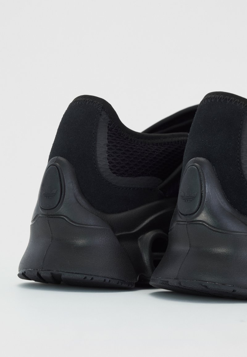 Baskets de sport noires avec une tige en mesh texturé, un design de talon arrondi et une semelle en caoutchouc durable avec un accent de logo.