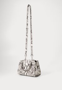 Taskeskuldertaske med slangepræg i hvid og sort, der har en struktureret form, dobbelte håndtag, justerbar rem og hardware i sølvtoner.