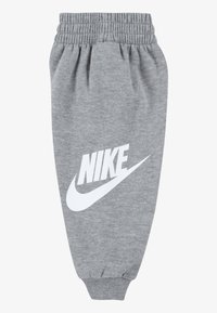 Calças de fato de treino cinzentas em algodão com um cós e punhos elásticos, apresentando um proeminente logotipo branco da Nike no quadril esquerdo.