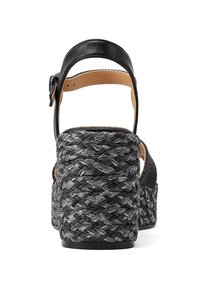 Sandal alto in pelle nera con una piattaforma intrecciata nera e grigia. Presenta un cinturino alla caviglia e dettagli in pelle liscia sul tacco.