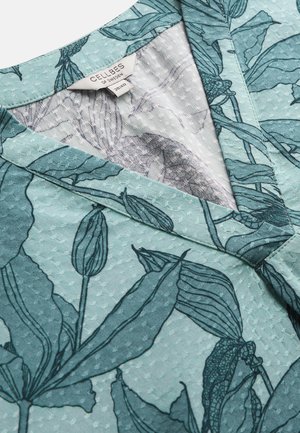 Vaaleanvihreä teksturoitu kangas, jossa tummanvihreä kasvikuvio ja V-muotoinen kaulus; vaatteessa on etiketti, jossa lukee "Cellbes of Sweden 38/40".