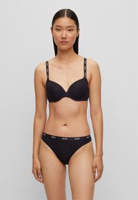 Soutien-gorge rembourré noir avec bretelles ajustables, arborant le logo 'BOSS', accompagné d'un slip de bikini noir assorti avec une ceinture logo.
