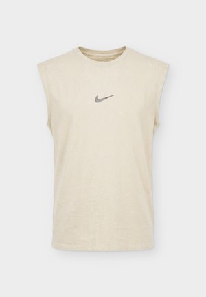 Mouwloos beige Nike tanktop met ronde hals en klein grijs Nike swoosh-logo in het midden van de borst op een witte achtergrond.
