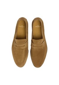 Bruna mockasinloafer i mocka med en slät textur, stickade detaljer, överdel i moccasinstil och en platt svart sula. Varumärkeslogotyp synlig inuti.