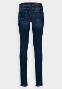 Jean skinny en denim bleu foncé, doté d'un design à cinq poches et d'une légère décoloration. Comprend une étiquette en cuir marron au dos à la taille.