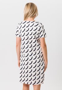 Korte mouwen jurk van lichtgewicht stof met een herhalend golfpatroon in zwart en crème, met een relaxte pasvorm en een knielengte.