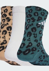 Drei Paar Socken: beige, weiß und petrol; jeweils mit einem schwarzen Leopardenmuster. Aus gestricktem Material gefertigt, mit gerippten Bündchen.
