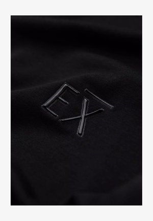 Zwarte stof met een verhoogd zwart logo "EX" in glanzend materiaal. De textuur is glad met een subtiele glans, wat het monochrome ontwerp benadrukt.