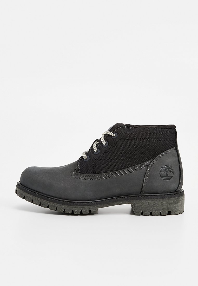 Botines grises con parte superior de cuero suave y un lateral de tela texturizada. Presentan cordones redondos, un cuello acolchado y una suela de goma resistente.