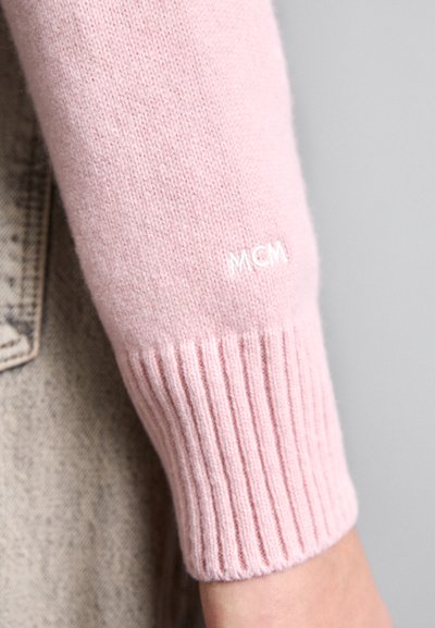 Roze gebreide trui mouw met geribbelde manchetten en witte "MCM" borduring. Zachte textuur, aansluitend ontwerp. Casual stijl detail.