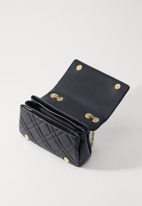 Borsa a tracolla nera trapuntata con hardware dorato, dotata di chiusura a pattina e tracolla a catena. L'interno presenta più scomparti per una migliore organizzazione.