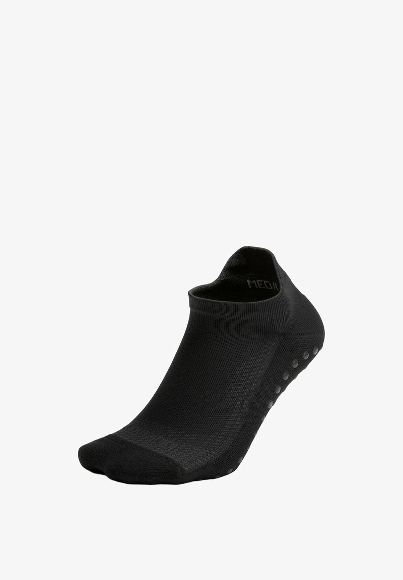 Schwarze Knöchelsocke aus glattem, elastischem Stoff. Mit strukturiertem Grip an der Unterseite und niedrigem Schnitt ohne sichtbare Logos.