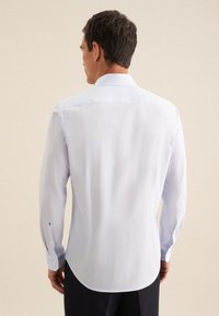 Camicia a maniche lunghe azzurro chiaro con un sottile motivo a righe. Presenta un colletto a punta e polsini con bottoni. Materiale in cotone, vestibilità slim.