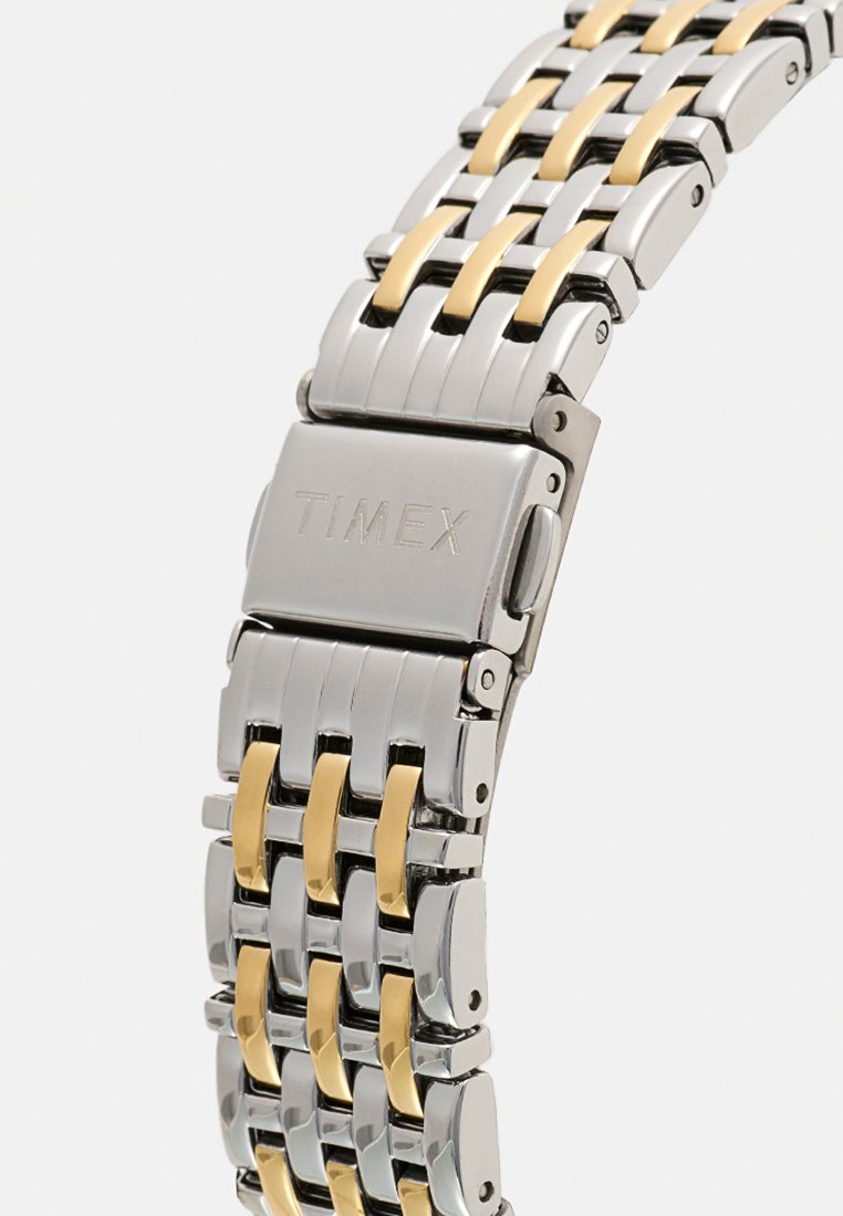 Zegarek na rękę Timex z bransoletą ze stali nierdzewnej i metalu w kolorze złotym, z na przemian ułożonymi srebrnymi i złotymi ogniwami, oraz bezpiecznym zapięciem.