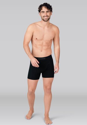 Zwarte boxershorts voor mannen met een aansluitend design, gemaakt van een gladde stof, voorzien van een tailleband met logo en contrasterende stiksel details.