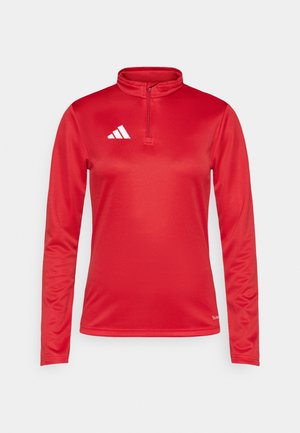 Haut de sport rouge à manches longues avec un col montant et une fermeture éclair quart. Présente le logo Adidas blanc sur le côté gauche de la poitrine. Tissu lisse et évacuant l'humidité.