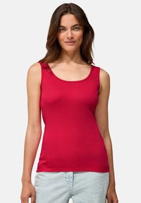 Top de tirantes rojos sin mangas en tejido suave, con escote en forma de barco y silueta ajustada. Diseño simple sin patrones visibles.