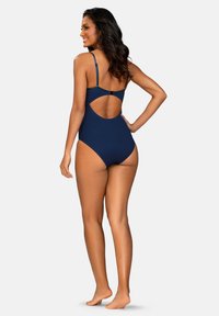 Granatowy jednoczęściowy strój kąpielowy z cienkimi, regulowanymi ramiączkami, otwartym tyłem oraz gładką, elegancką teksturą.