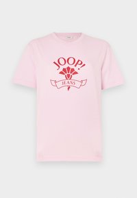 Růžové bavlněné tričko s výrazným červeným logem a textem "JOOP! JEANS" a dekorativními akcenty. Krátké rukávy a design s kulatým výstřihem.