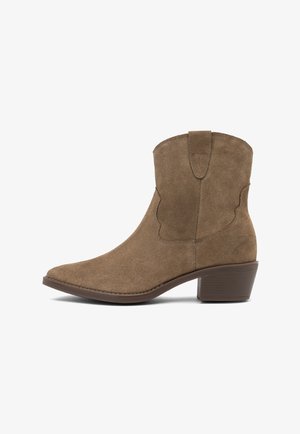 Stivali alla caviglia in suede marrone con punta appuntita, dettagli in cucitura curvata e tacco impilato. Il design include un fusto di altezza media con ritagli laterali.