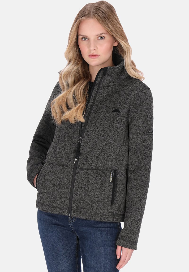 Szenes szürke polárdzseki magas gallérral, cipzáras záródással, két elülső zsebbel és egy finom logóval a mellrészen. Texturált anyag.