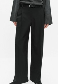 Czarne, dopasowane spodnie z wysokim stanem, szerokimi nogawkami i fałdami z przodu. Materiał ma gładką fakturę; stylizowane z cienkim paskiem.