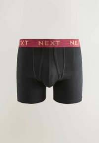 Fekete boxer alsónadrág bordó elasztikus derékpánttal, amelyen arany betűkkel a "NEXT" felirat található. Simább anyagú és fitted kialakítású, varrás részletezéssel.