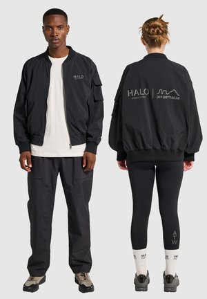 Schwarze Bomberjacke mit Seitentaschen, gerippten Bündchen und einem Reißverschluss. Mit "HALO"-Branding in Grau auf der Vorder- und Rückseite.