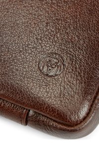 Brun läderplånbok med en texturerad yta, som har en svagt präglad logotyp. Rundade kanter och en slät finish förstärker designen.