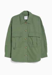 Grön Oversized-jacka med nedfällbar krage, knappstängning och två stora bröstfickor. Tillverkad av lättviktigt material med synlig sömnad.