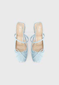 Scarpe slingback azzurre con finitura lucida, punta quadrata, sottili cinturini alla caviglia e un fiocco decorativo sul davanti.