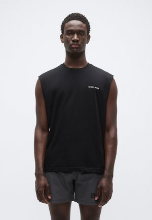 Tricou negru fără mâneci din bumbac, cu guler rotund și mic logo alb „BJÖRN BORG” pe partea stângă, asortat cu pantaloni scurți atletici gri.