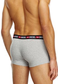 Graue Baumwoll-Boxershorts mit einem schwarzen Bund, der das "DIESEL"-Logo in Rot trägt. Weicher Stoff, enganliegendes Design und mittellange Beinlänge.