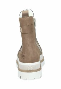 Bottine en suede marron avec une semelle blanche, dotée d'une fermeture éclair sur le côté, d'une sangle décorative et d'un logo sur le talon. Texture lisse sur l'ensemble.